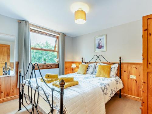 a bedroom with a bed with yellow pillows at 2 Bed in Ledbury oc-77377 in Yatton