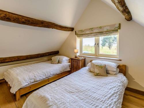two beds in a room with a window at 2 Bed in Thame oc-cc068 in North Aston