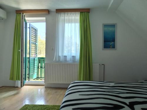 a bedroom with a bed and a large window at VILLa LIKA A NNEX in Plitvička Jezera