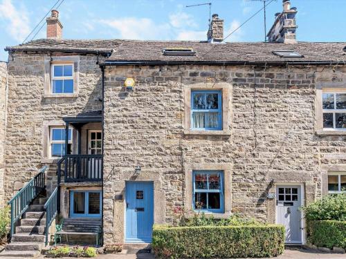 an old stone house with a blue door at 3 Bed in Baslow oc-pk908 in Baslow