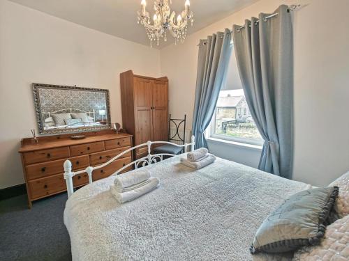 a bedroom with a bed and a dresser and a window at 3 Bed in Morpeth oc-96236 in Amble