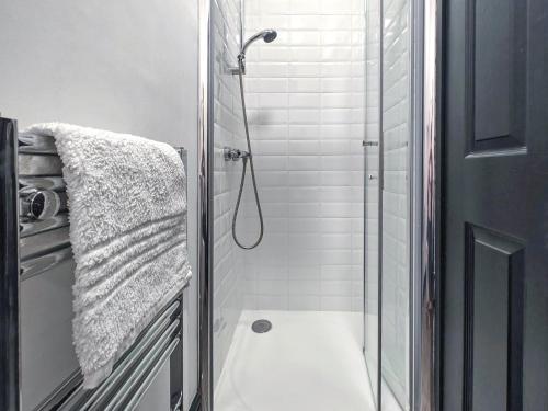 a bathroom with a shower with a glass door at 3 Bed in Morpeth oc-96236 in Amble
