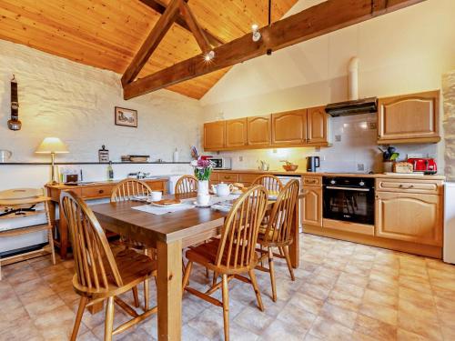 a large kitchen with a wooden table and chairs at 2 Bed in Dulverton oc-90558 in Dulverton