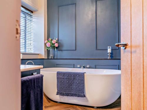 a bathroom with a white tub and a sink at 6 Bed in Huddersfield oc-93984 in Huddersfield