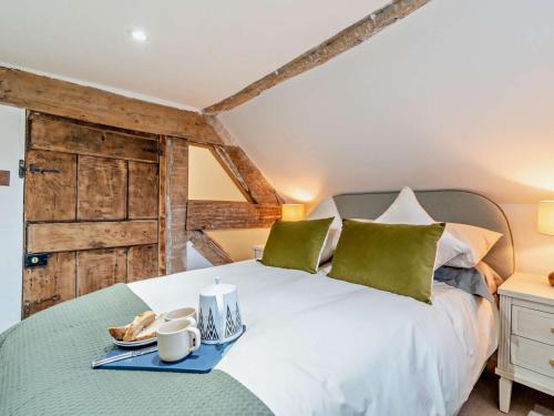 a bedroom with a white bed with green pillows at 3 Bed in Warwick oc-93887 in Kineton