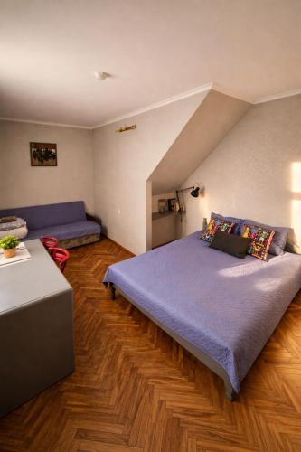 a bedroom with a large bed and a couch at Muzeja apartamenti & Free Parking & Self Check-in in Riga