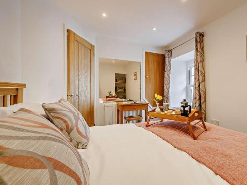 a bedroom with a white bed and a table at 2 Bed in Aberdovey oc-91962 in Aberdyfi