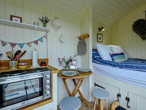 a room with a bed and a small table with a microwave at 1 Bed in Hereford oc-93440 in Little Dewchurch