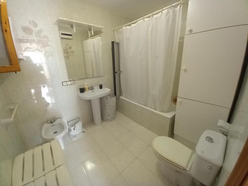 a white bathroom with a toilet and a sink at Marcolina, 2 in Alcalà de Xivert