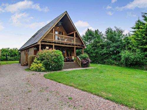 a large log cabin with a porch and a balcony at 3 Bed in Ledbury oc-77379 in Yatton