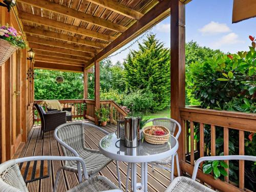 a patio with a table and chairs on a deck at 3 Bed in Ledbury oc-77379 in Yatton