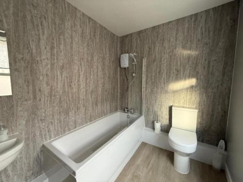 a bathroom with a tub and a toilet and a sink at 2 Bed in Oswestry oc-76537 in Gobowen