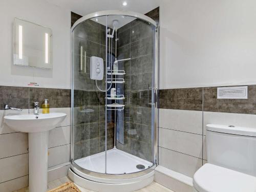 a bathroom with a shower and a toilet and a sink at 3 Bed in Monmouth oc-52149 in Welsh Newton Common