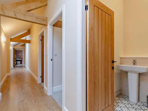 a hallway with a bathroom with a sink and a door at 5 Bed in Leek oc-79543 in Grindon