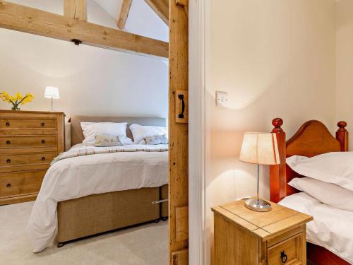 a bedroom with a bed and a lamp on a table at 5 Bed in Leek oc-79543 in Grindon