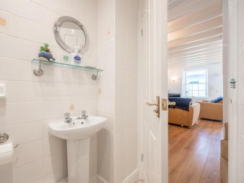 a white bathroom with a sink and a mirror at 2 Bed in Aberdyfi oc-dy047 in Aberdyfi