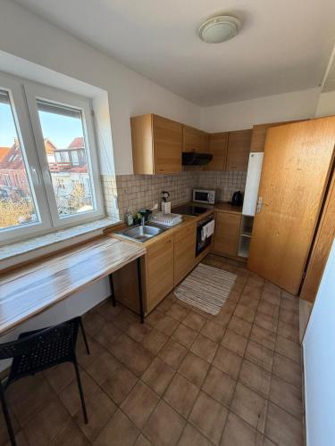 a kitchen with wooden cabinets and a sink and a window at Deichnest in Hollern-Twielenfleth