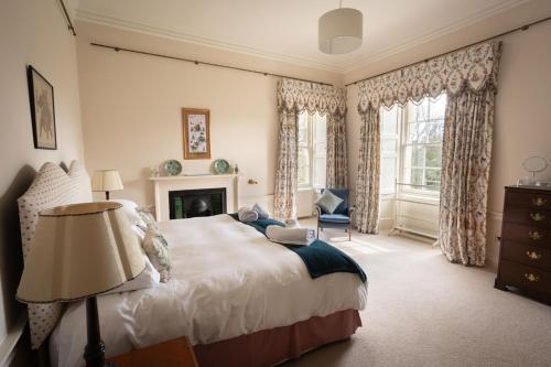a bedroom with a large bed and a fireplace at Dalvey House in Forres