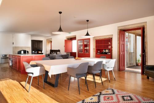 a kitchen and dining room with a white table and chairs at Casa Dr Ramiro Salgado - Douro Superior, Torre de Moncorvo in Torre de Moncorvo
