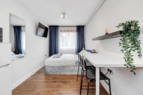 a white room with a desk and a bed at The ground floor Green Oasis, near the station in London
