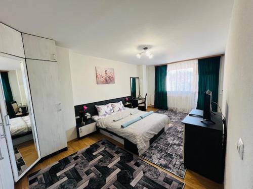 a bedroom with a bed and a television in it at Апартамент за гости in Razlog