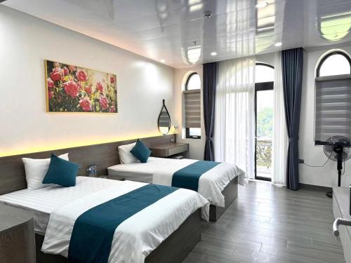 a hotel room with two beds and a window at Sky Night Hotel 2 in Việt Yên
