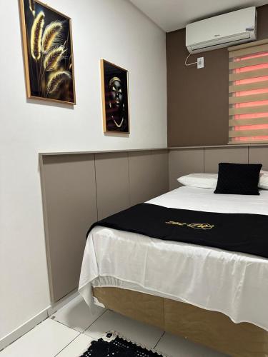 a bedroom with a bed with a black and white blanket at Flat JK 202 in Juazeiro do Norte