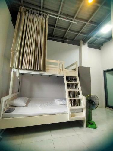 a white bunk bed in a room with a fan at Kidona's House in Danang