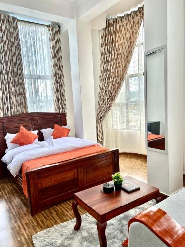 a bedroom with a large bed and a table at Sumni Hotel in Nkoanrua