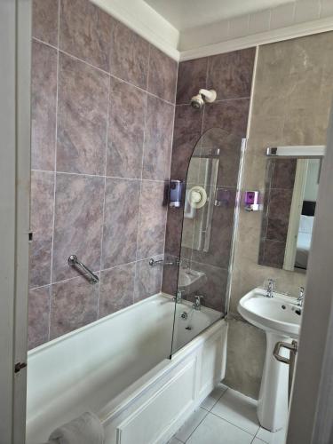ein Badezimmer mit Dusche, Badewanne und Waschbecken in der Unterkunft Imperial Accommodation Tralee in Tralee