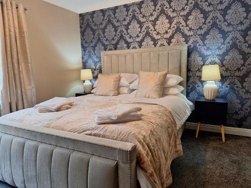 a bedroom with a large bed with two lamps on tables at Old Coach House Apartment with Garage in Scarborough