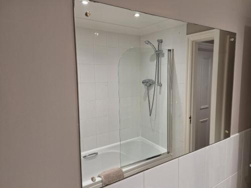 a mirror in a bathroom with a shower at Old Coach House Apartment with Garage in Scarborough