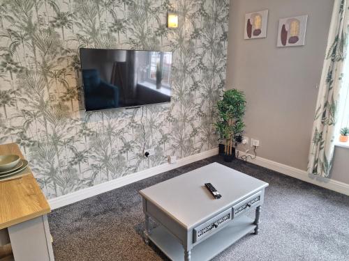 a living room with a tv on a wall at Old Coach House Apartment with Garage in Scarborough