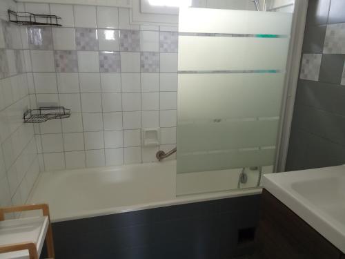 a bathroom with a shower with a tub and a sink at Le lagon zen in Ploufragan