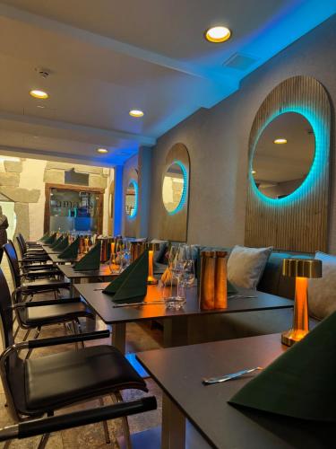 a row of tables in a restaurant with blue lights at Anker Self-Check-In Hotel in Lindau