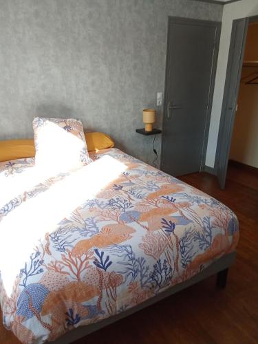 a bedroom with a bed with a colorful comforter at Le lagon zen in Ploufragan