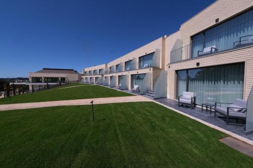 a building with a green lawn in front of it at Quinta da Maquia Hotel in Sintra