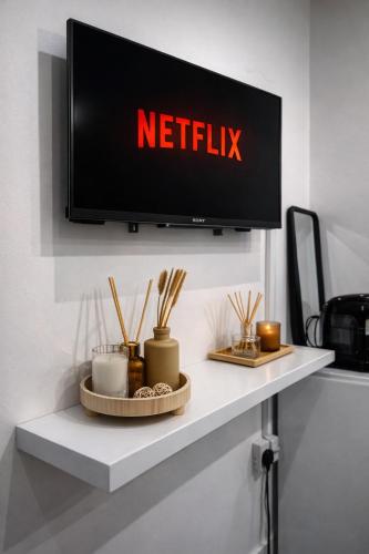 a tv on a shelf with a netflix sign on it at Tambo Apartments in London