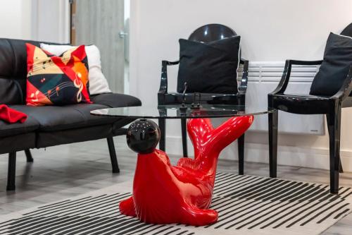 a red animal statue sitting on the floor in a living room at Tambo Apartments in London