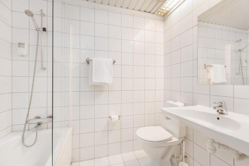 a white bathroom with a shower and a toilet and a sink at Highland Lodge in Geilo
