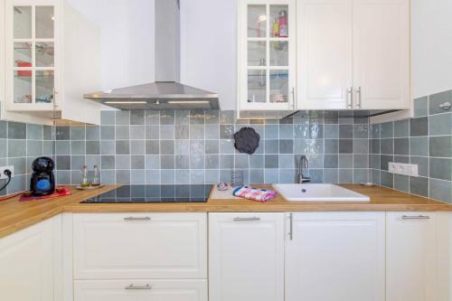 a kitchen with white cabinets and a sink at Villa Mare a fabulous hideaway in S'Algar