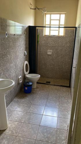 a bathroom with a shower and a toilet and a sink at Império Hotel in Costa Rica