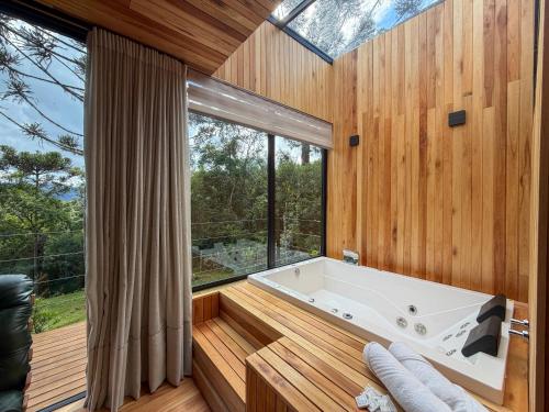 a large bathroom with a tub and a large window at Mökki Cabanas de Altitude INAUGURAÇÃO ABRIL 2026 in Urubici