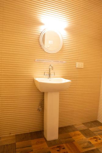 a bathroom with a sink and a mirror on the wall at The Lume, Lachung in Lachung
