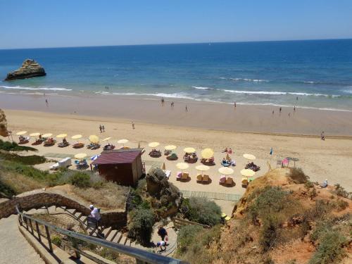 a beach with umbrellas and people on the beach at Buzios Praia da Rocha in Portimão