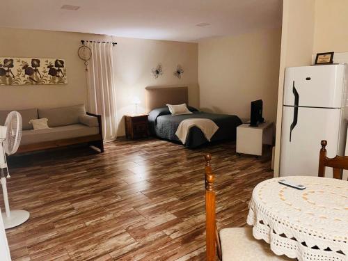 a bedroom with a bed and a refrigerator in it at Corazón de Ayrampos APART in Villa Dolores