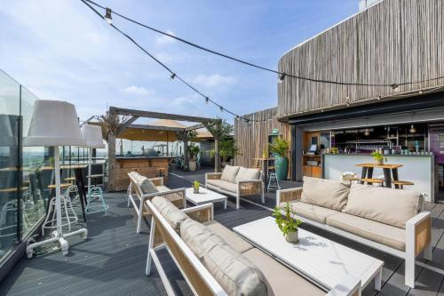 a patio with couches and tables on a building at Leonardo Hotel Amsterdam Rembrandtpark in Amsterdam