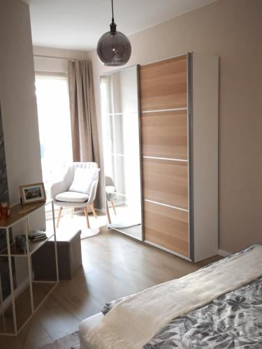 a bedroom with a sliding closet door with a chair at Superior - Appartement Amélie in Potsdam