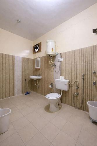 a bathroom with a toilet and a sink at Trippy Turtle Hostel in Manāli