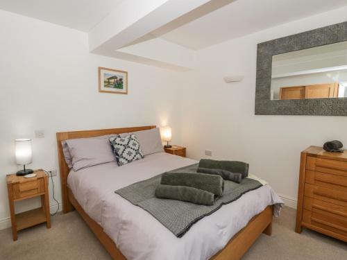 a bedroom with a bed with two green pillows on it at Awen Ingli in Newport